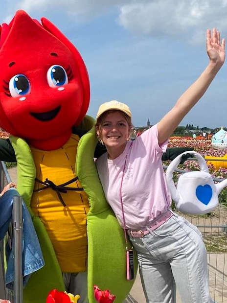 Visitors posing with a tulip mascot in Amsterdam tulip fields during a small group tour.