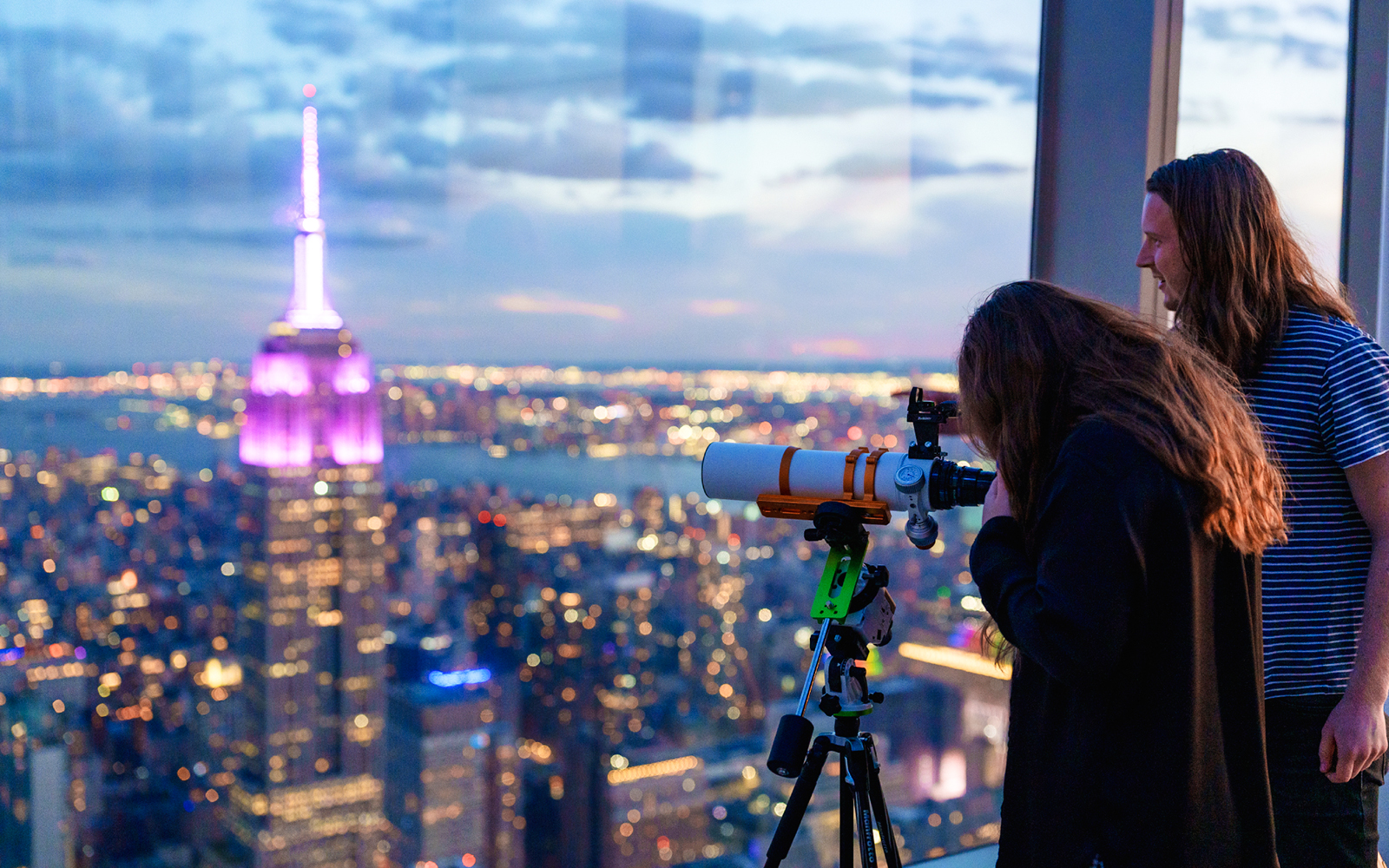 Visitors stargazing through telescopes at Summit One Vanderbilt, New York City, during Astronomy Nights event.