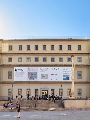 Reina Sofia Museum entrance with visitors and modern art banners, Madrid.