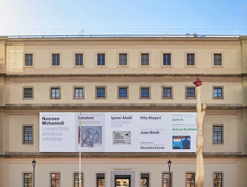 Reina Sofia Museum entrance with visitors and modern art banners, Madrid.