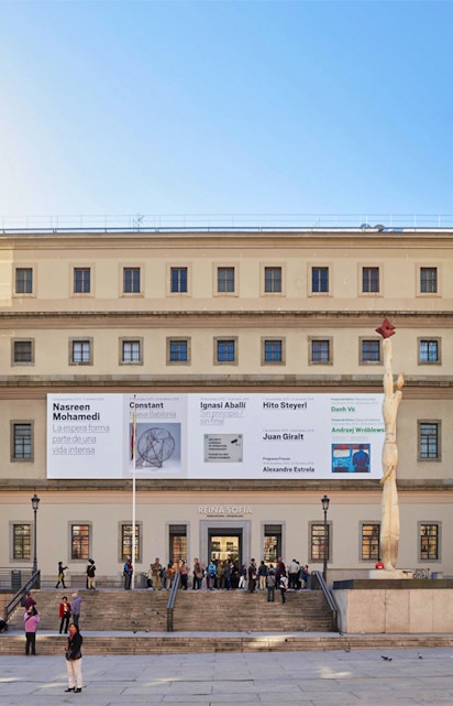 Reina Sofia Museum entrance with visitors and modern art banners, Madrid.