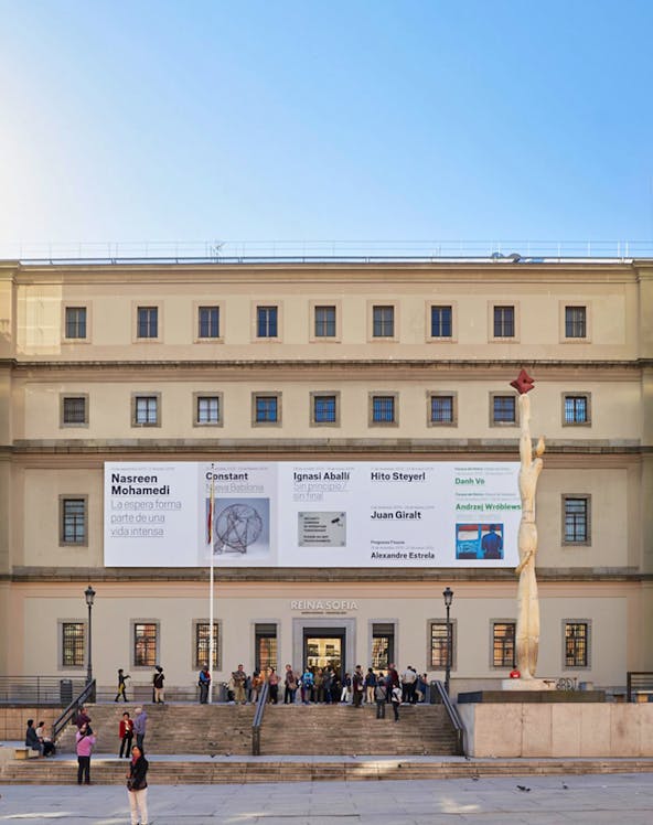 Reina Sofia Museum entrance with visitors and modern art banners, Madrid.