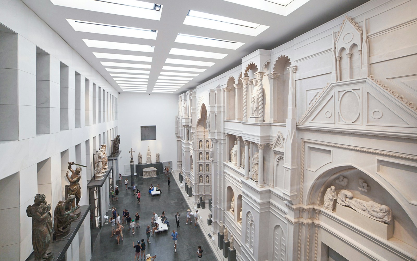 Interior of Opera del Duomo Museum, Pisa, showcasing sculptures and architectural details.
