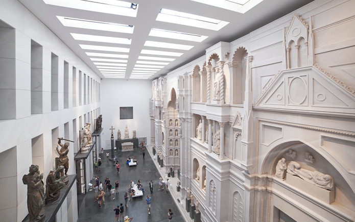 Interior of Opera del Duomo Museum, Pisa, showcasing sculptures and architectural details.