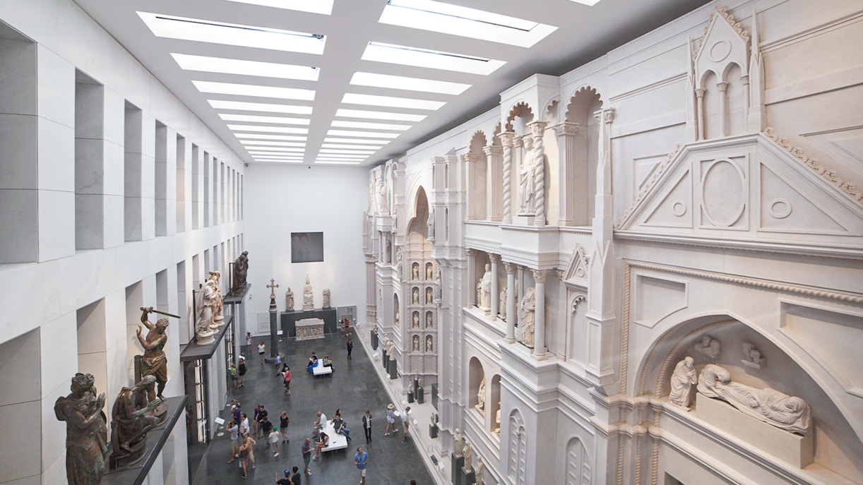 Interior of Opera del Duomo Museum, Pisa, showcasing sculptures and architectural details.