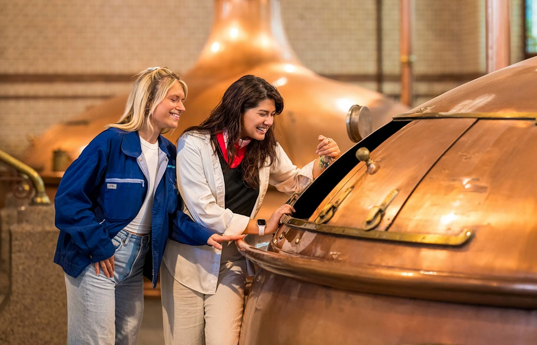 Guests exploring brewing equipment at the Heineken Experience.