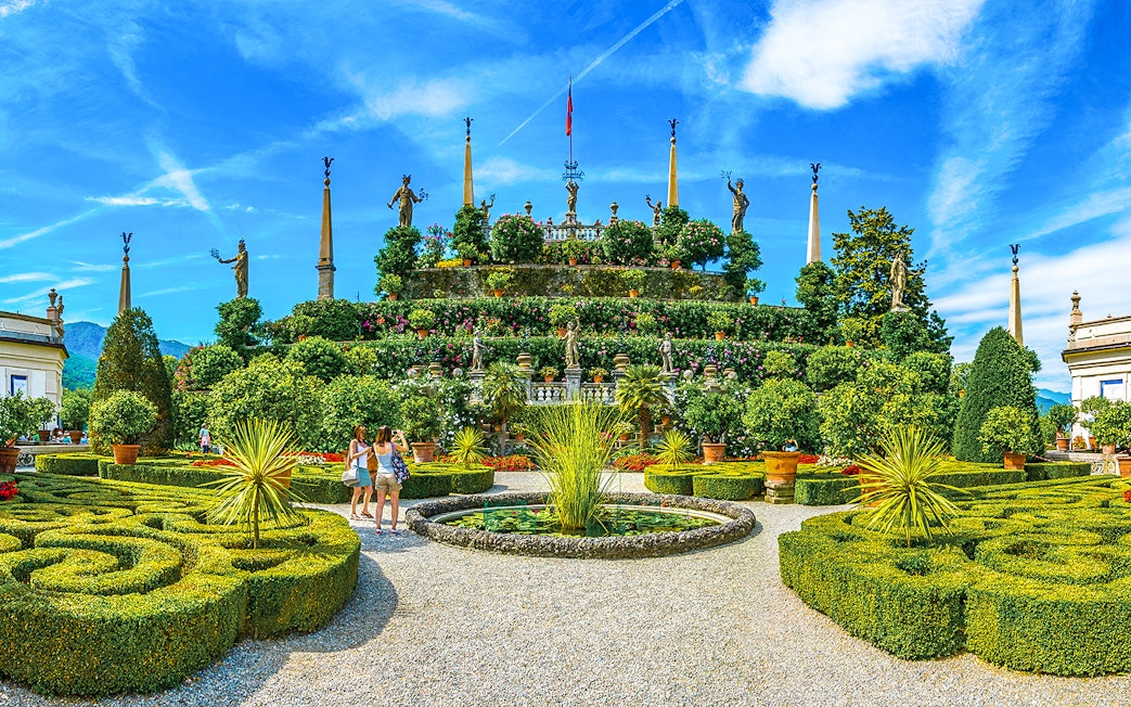 Isola Bella garden with statues and tourists, part of the Hop-on Hop-off Isole Borromee tour.