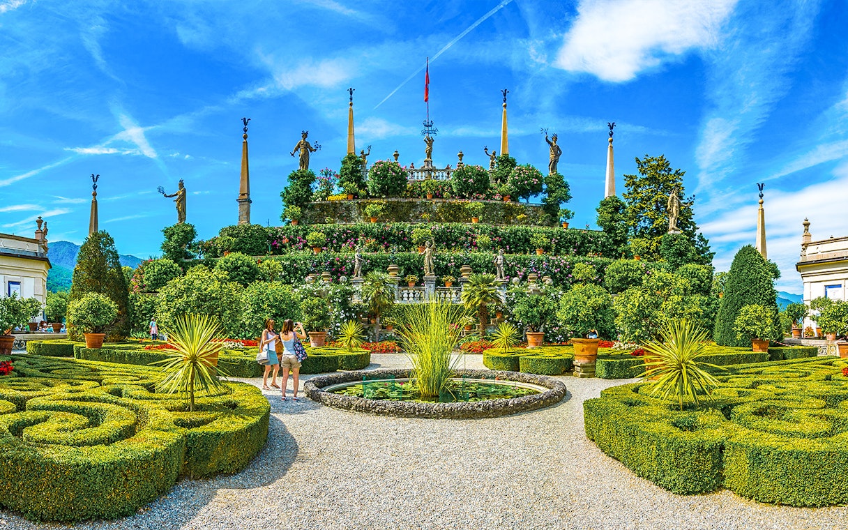 Isola Bella garden with statues and tourists, part of the Hop-on Hop-off Isole Borromee tour.