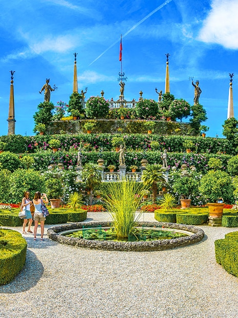 Isola Bella garden with statues and tourists, part of the Hop-on Hop-off Isole Borromee tour.