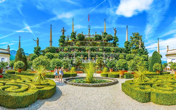 Isola Bella garden with statues and tourists, part of the Hop-on Hop-off Isole Borromee tour.