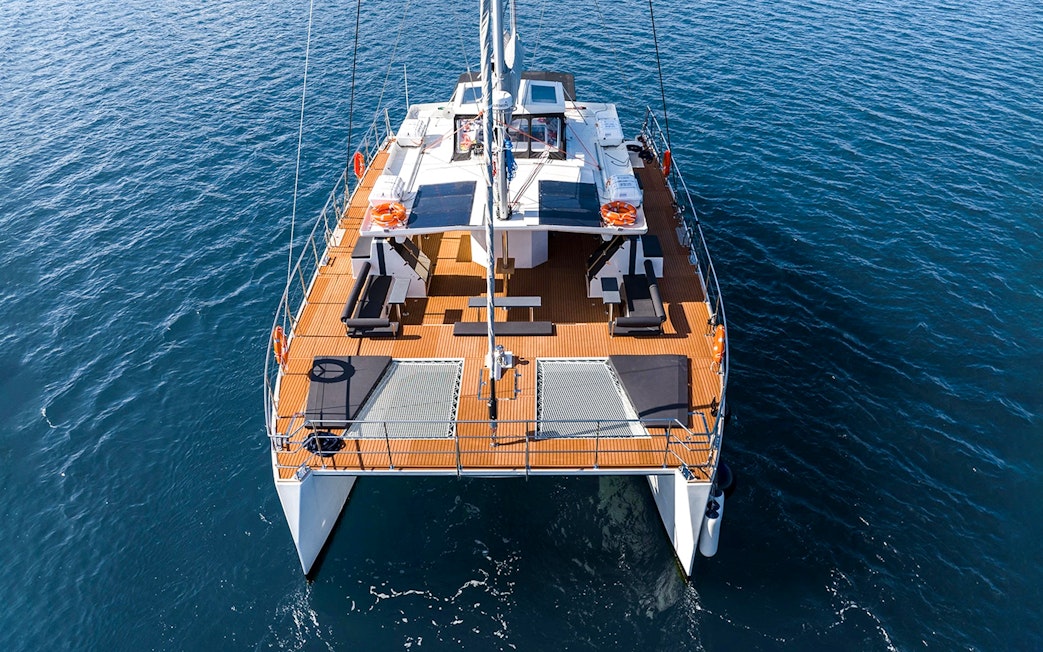 Catamaran on Santorini cruise with open deck and ocean view.