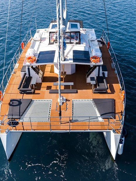 Catamaran on Santorini cruise with open deck and ocean view.