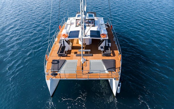 Catamaran on Santorini cruise with open deck and ocean view.