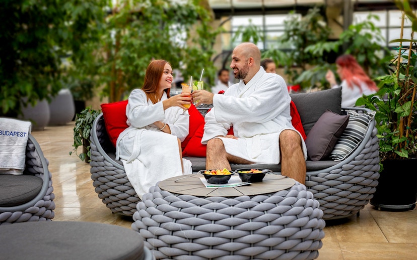 Guests toasting with drinks inside Szechenyi Bath Palm House, Budapest.