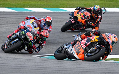 Motorcycle racers taking a sharp turn at Sepang International Circuit, Malaysia Grand Prix.