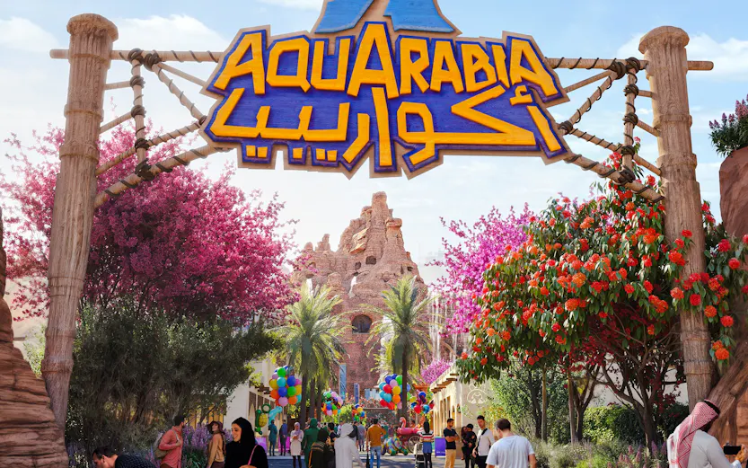 Entrance to Aquarabia theme park with visitors and colorful decorations.