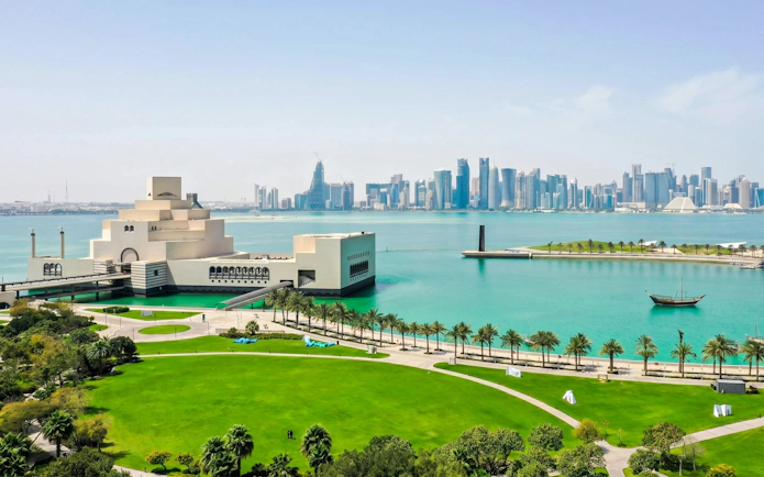 Museum of Islamic Art in Doha with city skyline and waterfront view.