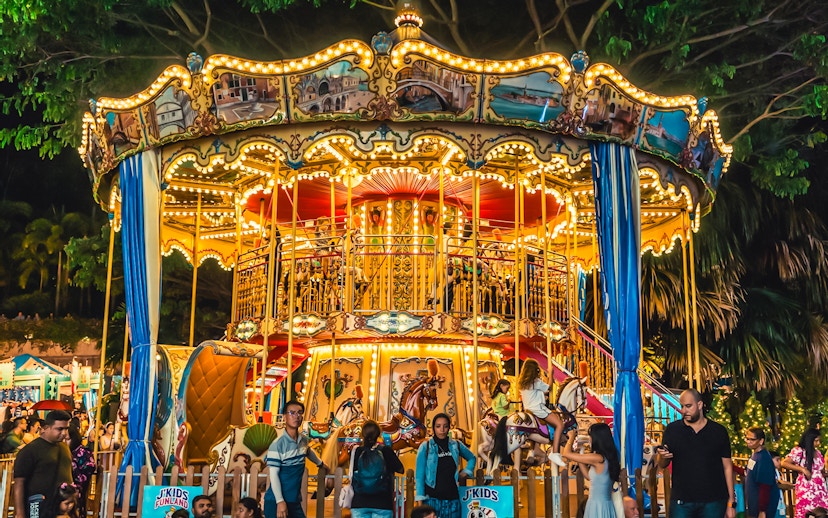 Children enjoying a carousel ride at Gardens by the Bay Christmas carnival.