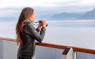 Person using binoculars on a whale watching tour in Juneau.