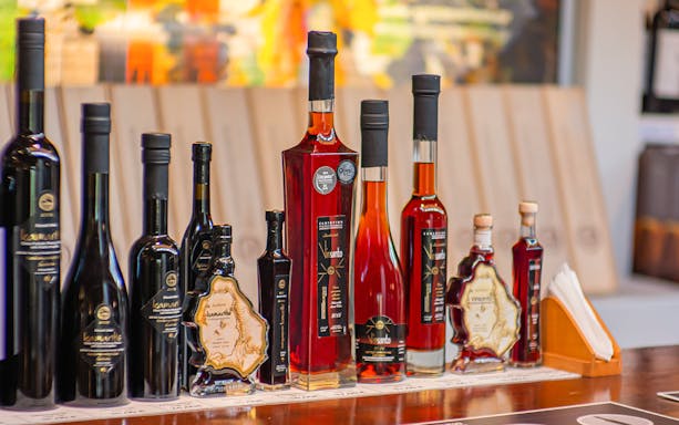 Santorini wine bottles displayed on a wooden counter during a sunset wine tour.