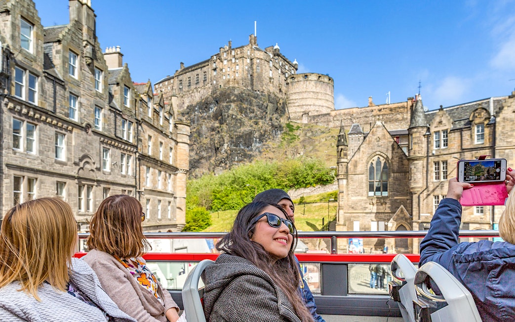 Tourists on a hop-on hop-off bus viewing Edinburgh Castle during the Royal Edinburgh Tour.