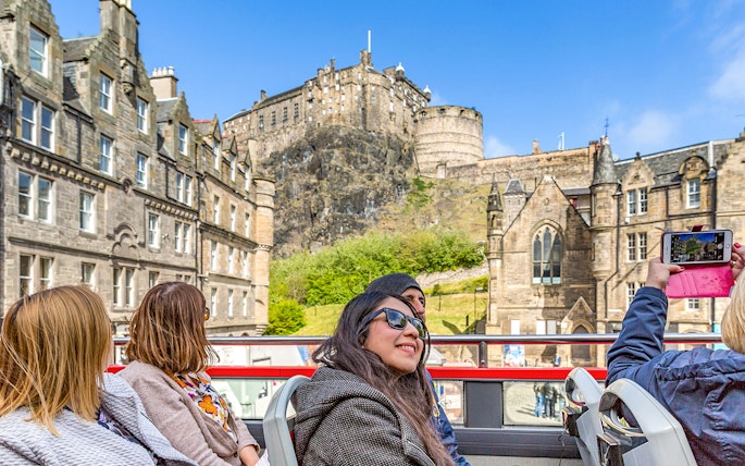 Tourists on a hop-on hop-off bus viewing Edinburgh Castle during the Royal Edinburgh Tour.