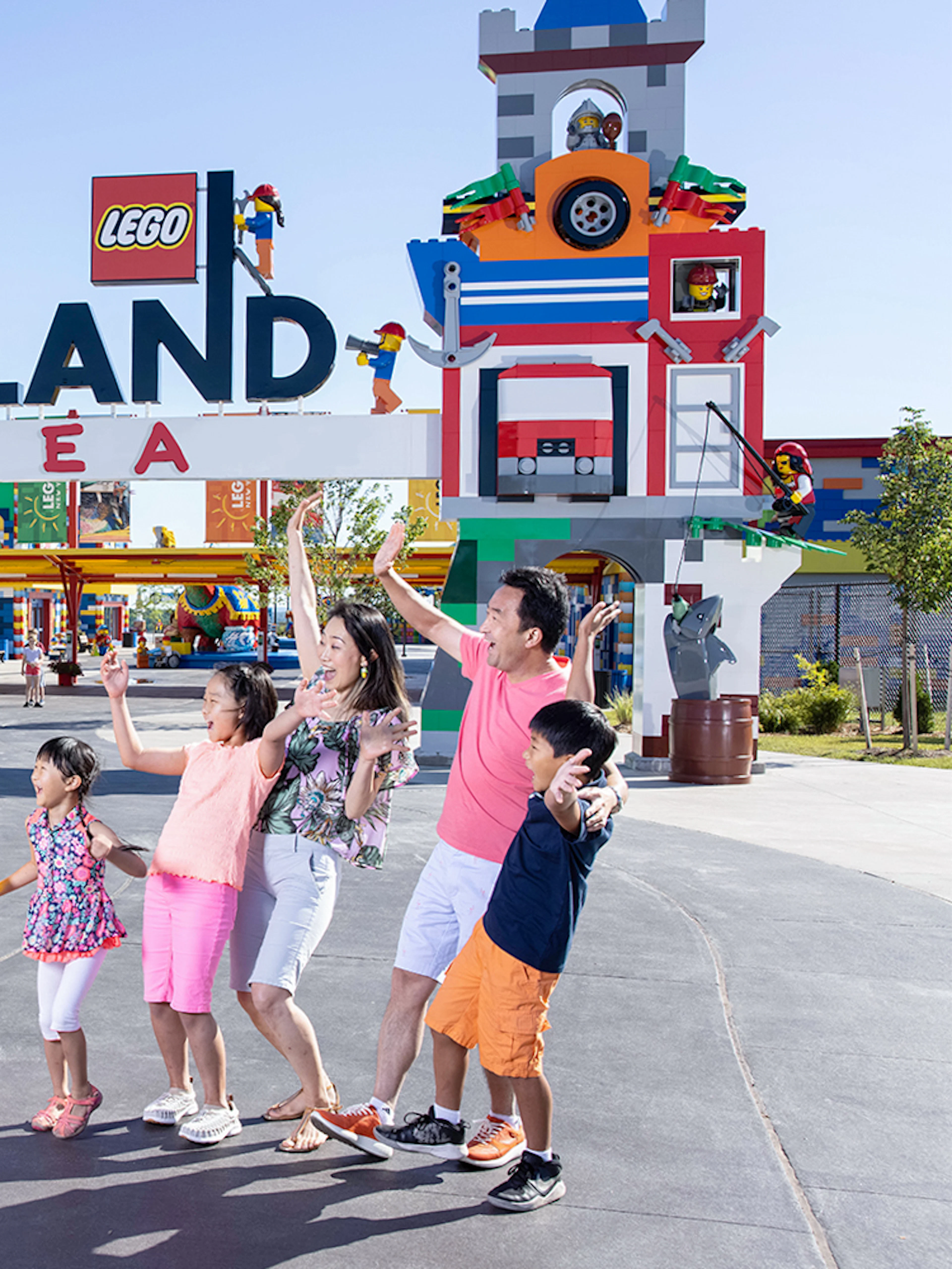 Family posing with Lego figures at Legoland Korea entrance.
