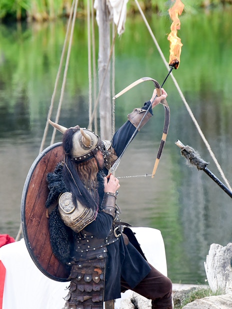 Viking reenactor with flaming arrow at Puy du Fou, France.