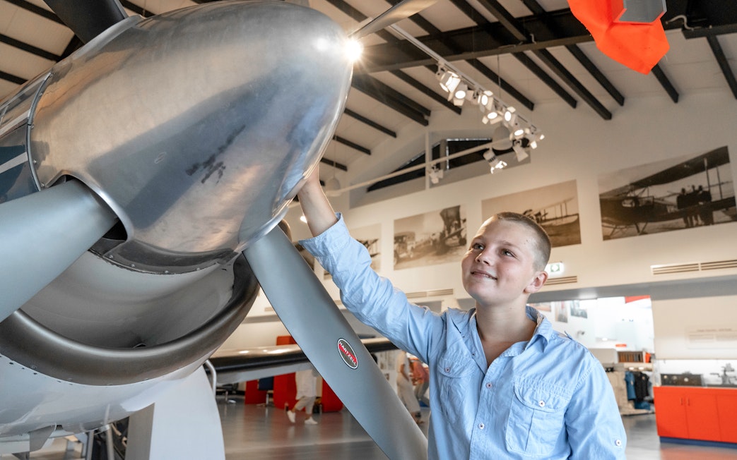 Young visitor exploring aircraft exhibit at Darwin Royal Flying Doctor Service museum.