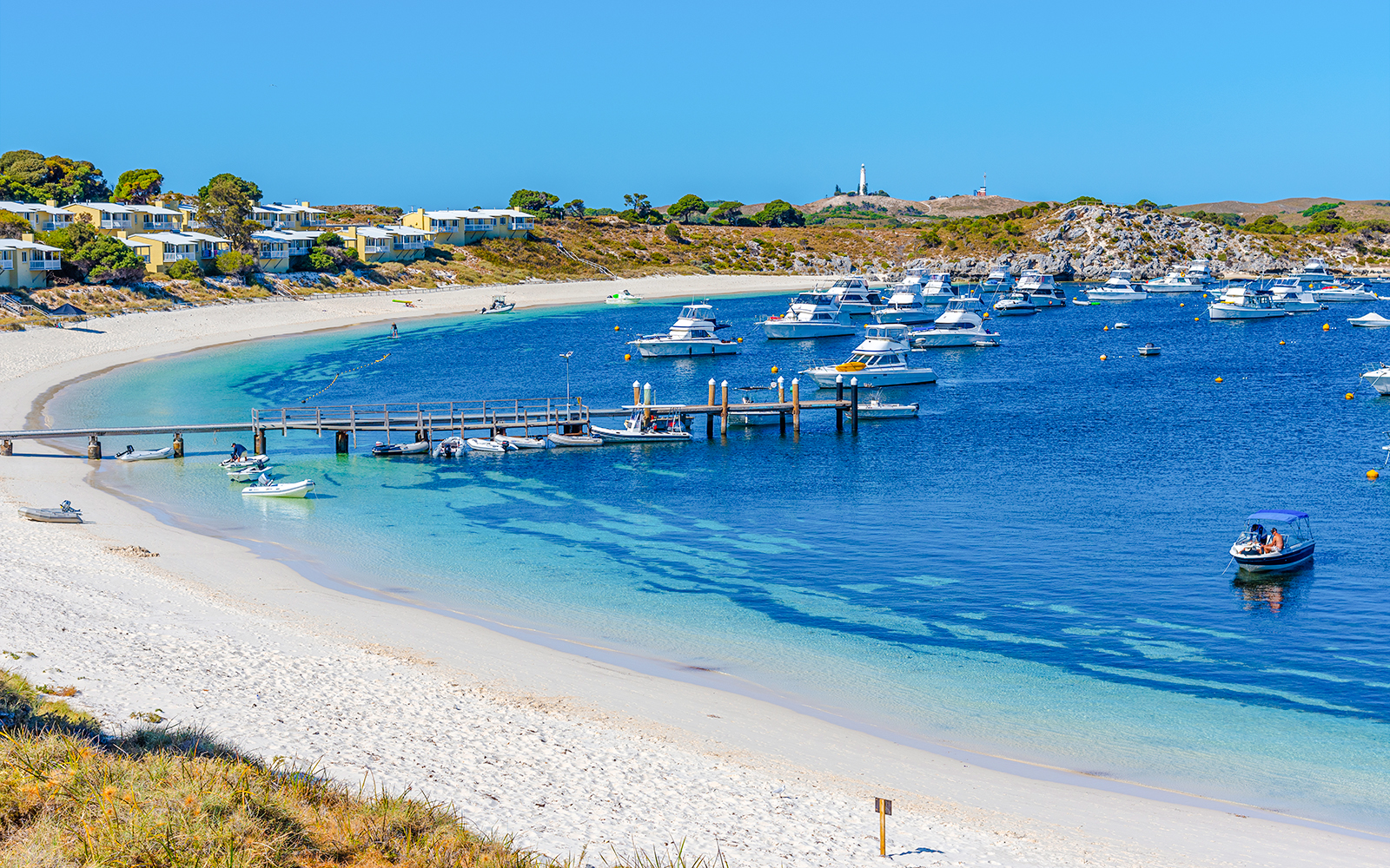 Boats moored at Geordie Bay, Rottnest Island, with sandy beach and clear blue water.