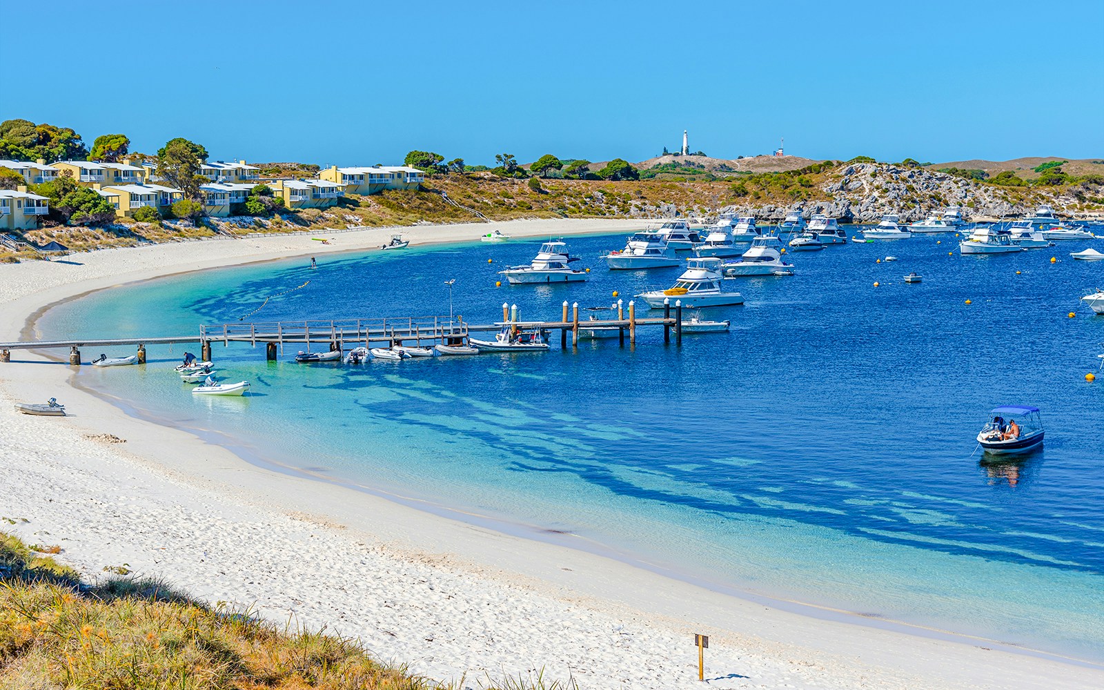 Boats moored at Geordie Bay, Rottnest Island, with sandy beach and clear blue water.