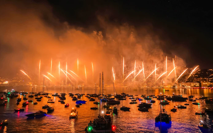 Fireworks over boats during sunset cruise in French Riviera.