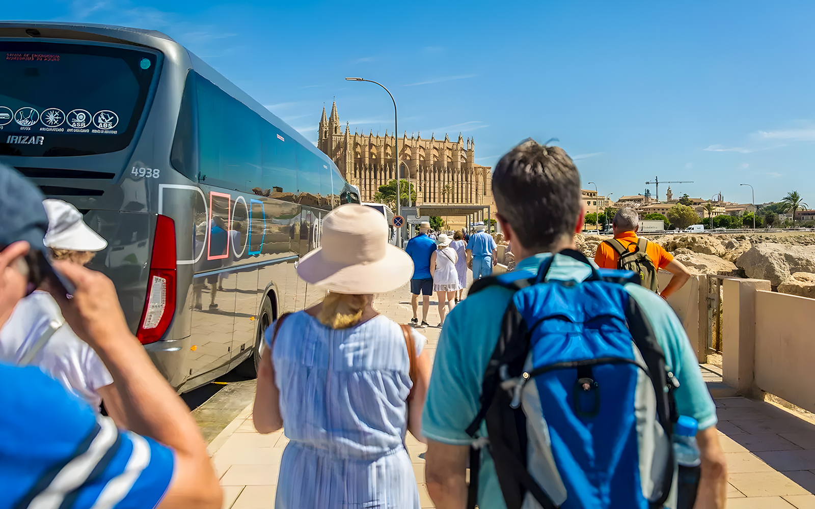 Visitors walking from bus towards Palma Cathedral in Mallorca.
