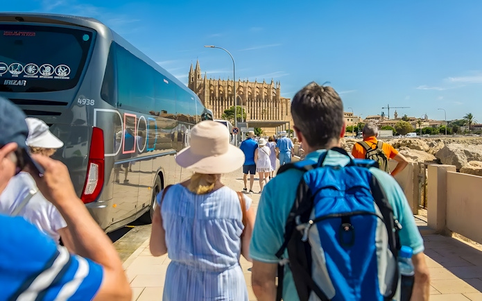 Visitors walking from bus towards Palma Cathedral in Mallorca.