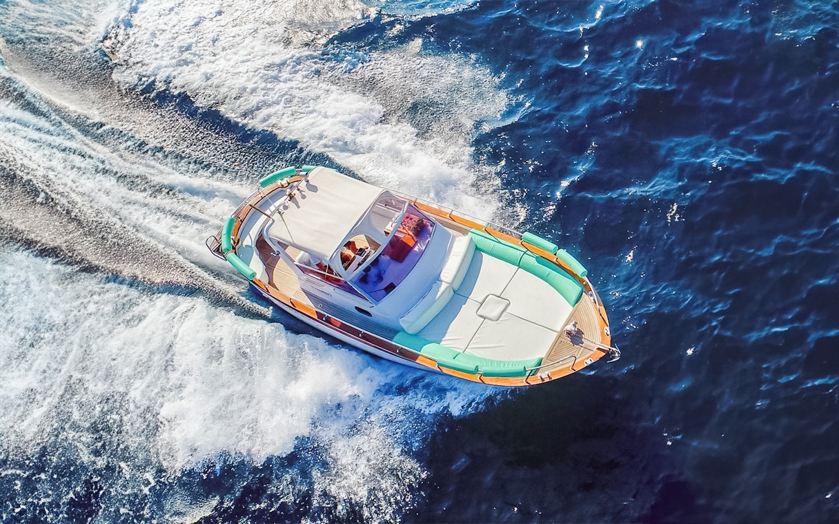 Boat cruising on blue waters during all-inclusive Capri tour from Pompeii or Naples.