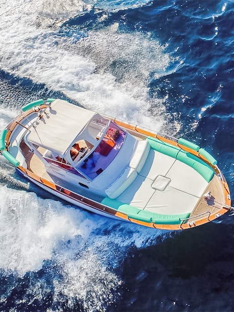 Boat cruising on blue waters during all-inclusive Capri tour from Pompeii or Naples.
