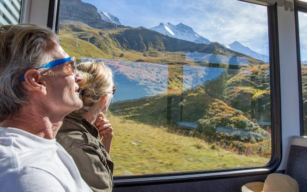 Passengers viewing mountain landscape from train window, Interrail Flexible Global Pass.