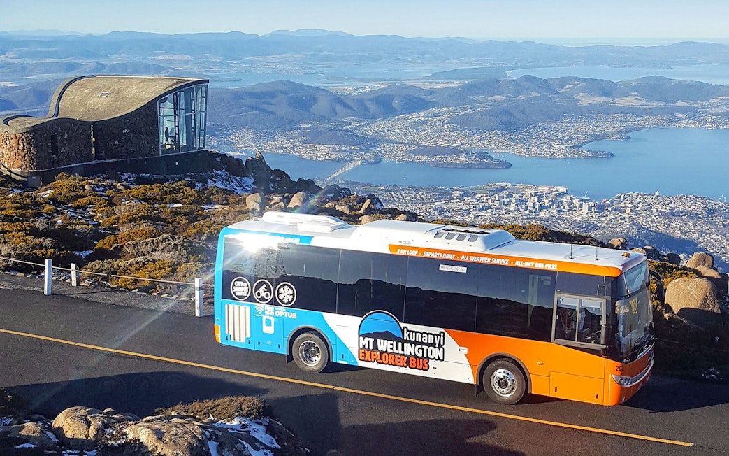 Kunanyi/Mt Wellington Explorer Bus with Hobart view in background.