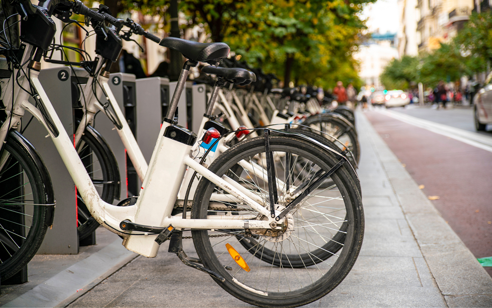 Public e-bike sharing station with parked bicycles in Madrid, Spain.