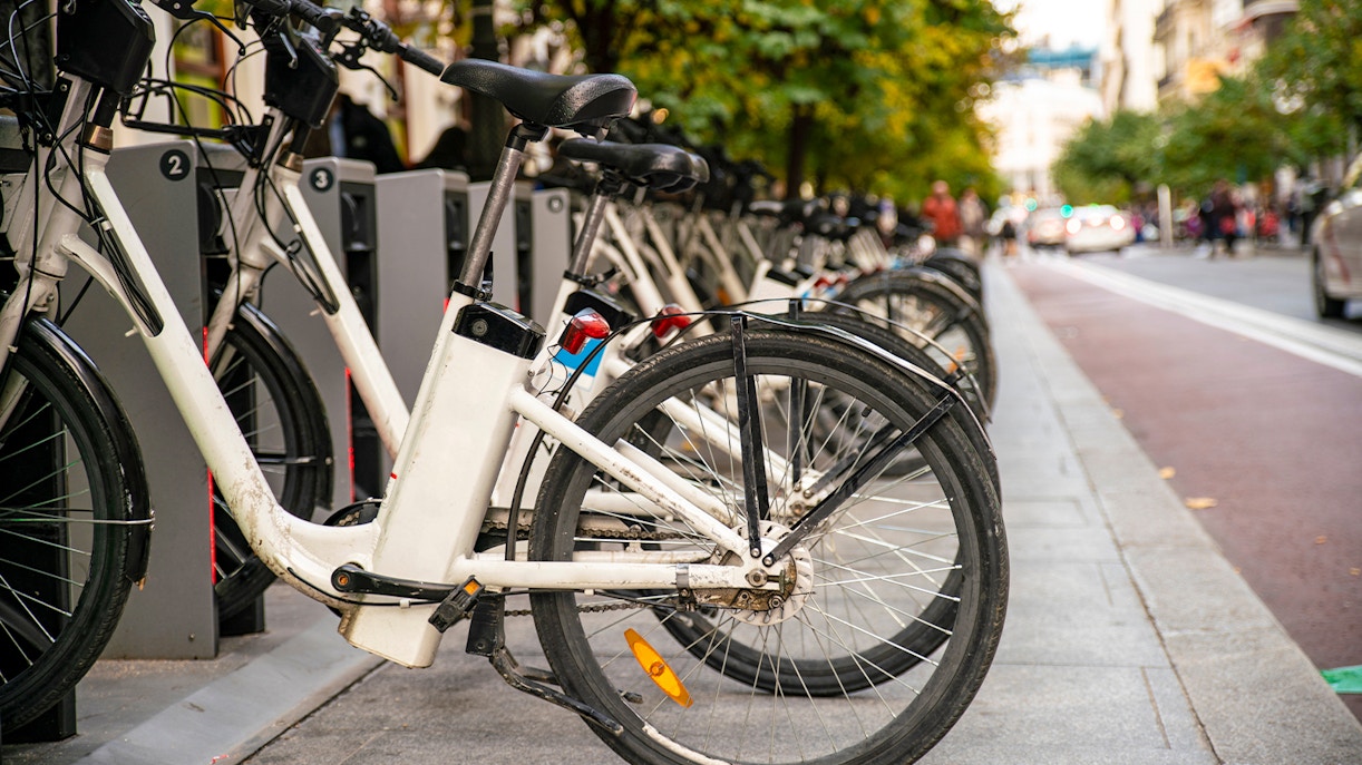 Public e-bike sharing station with parked bikes in Madrid, Spain.