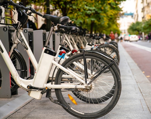 Public e-bike sharing station with parked bicycles in Madrid, Spain.