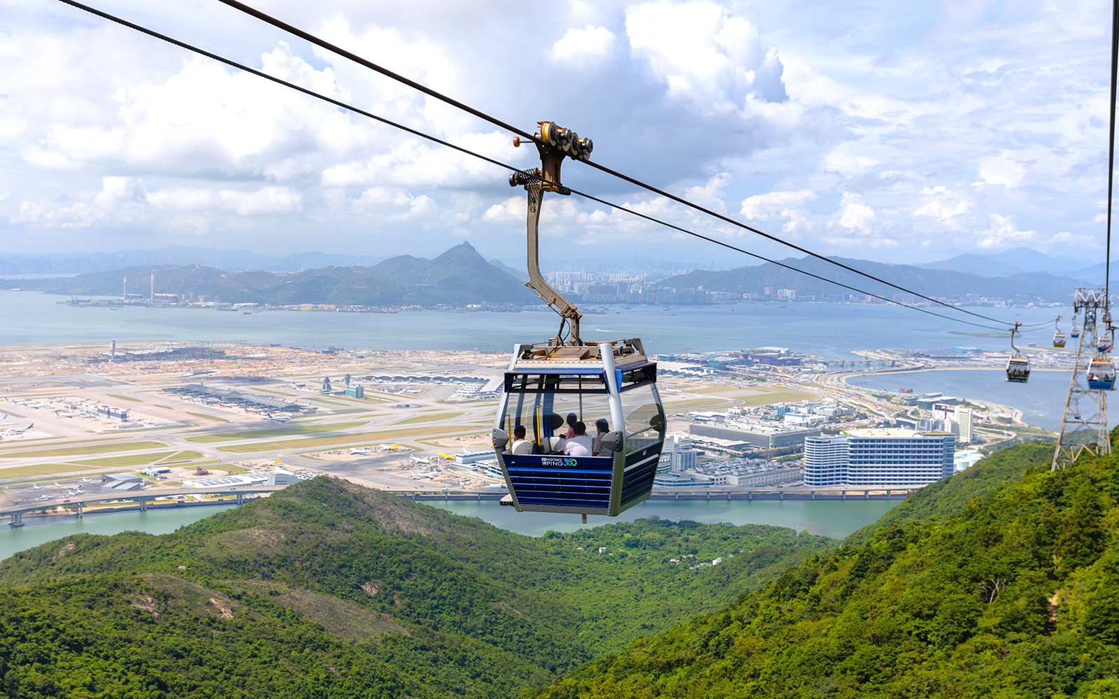 Cable car over Lantau Island with view of Hong Kong International Airport.