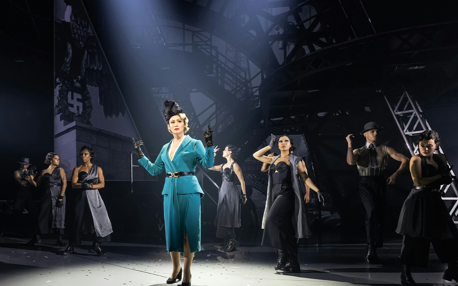 Performers on stage in a dramatic scene from the Lempicka show.