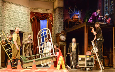 Cast members on stage during a chaotic scene from "The Play That Goes Wrong.