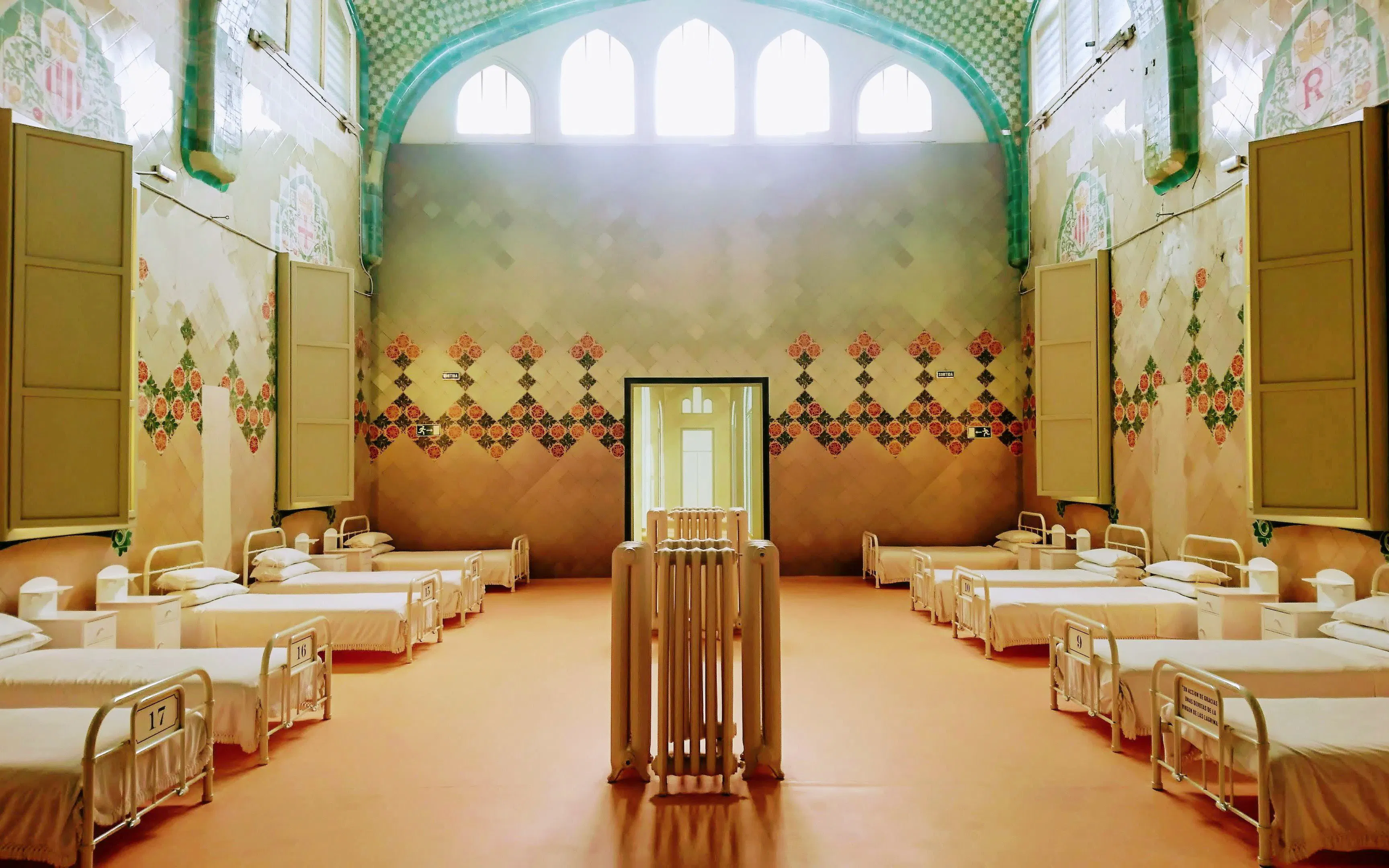 Sant Rafael Pavilion ward with ornate tiles and rows of beds at Recinte Modernista de Sant Pau.