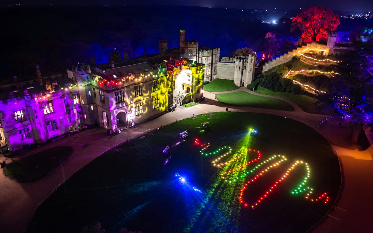 Aerial view of Warwick Castle Light Trail with colorful illuminated pathways.