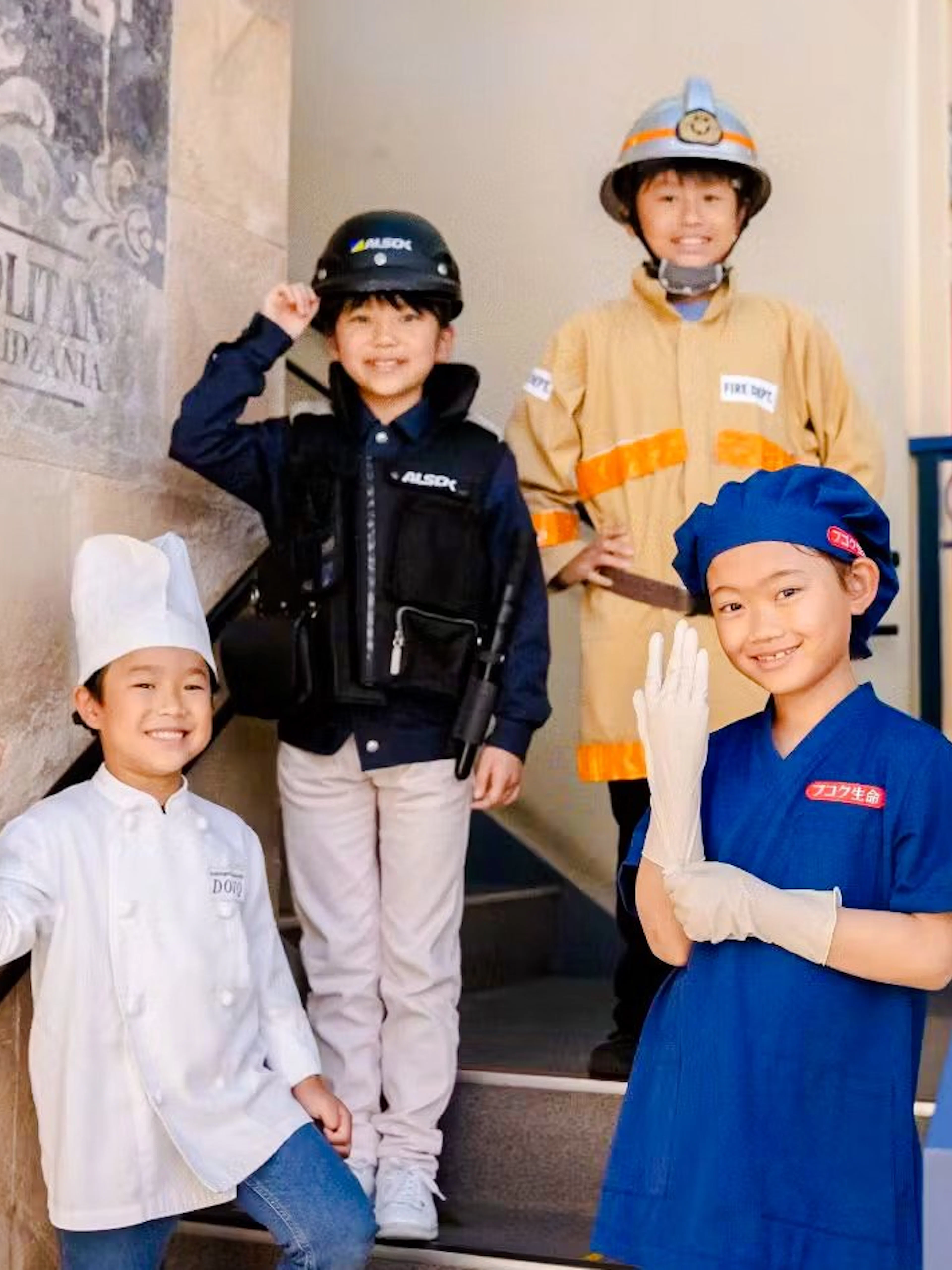 Children in various uniforms at KidZania Osaka Koshien, engaging in role-play activities.