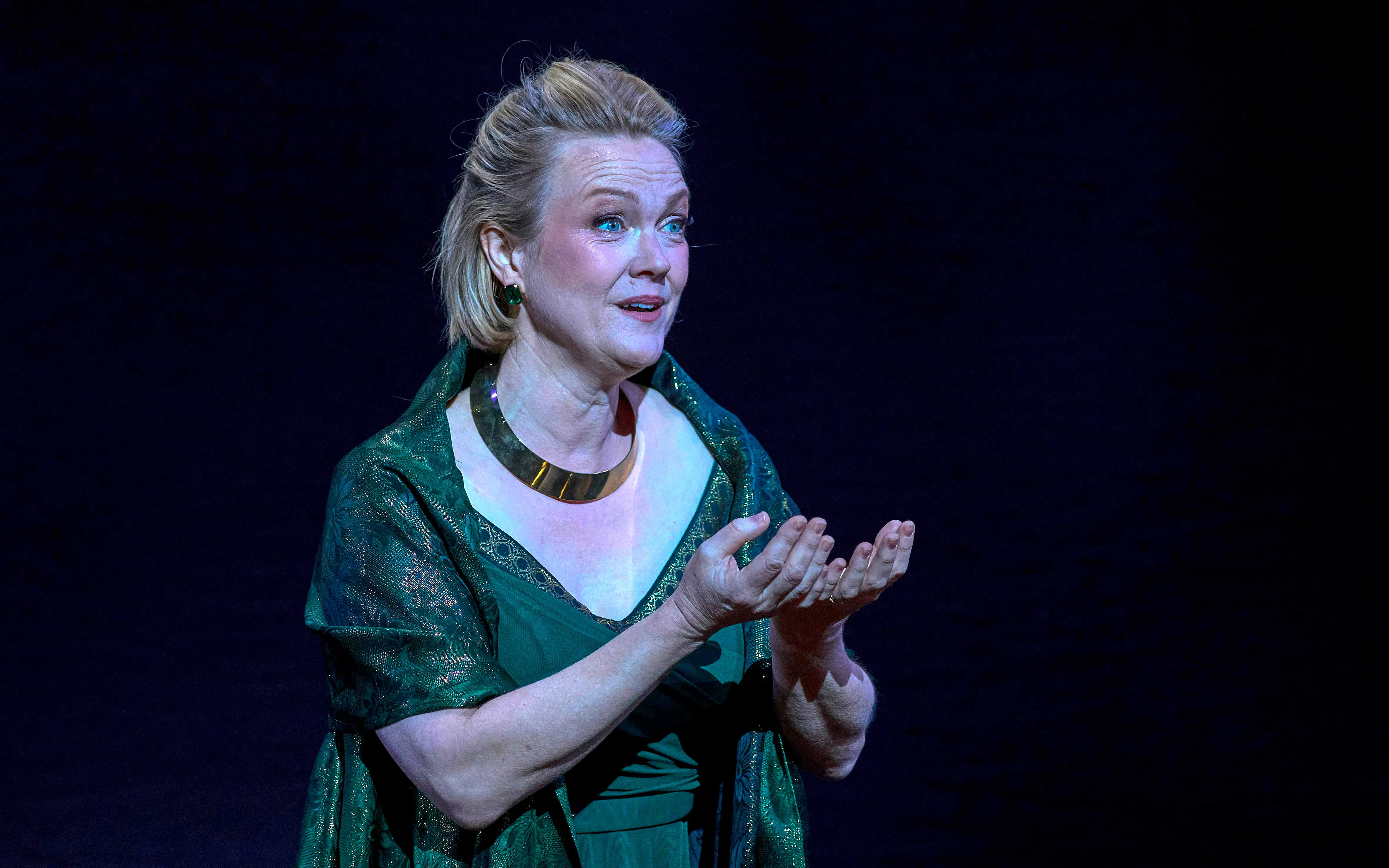 Performer in green dress on stage during My Fair Lady show.