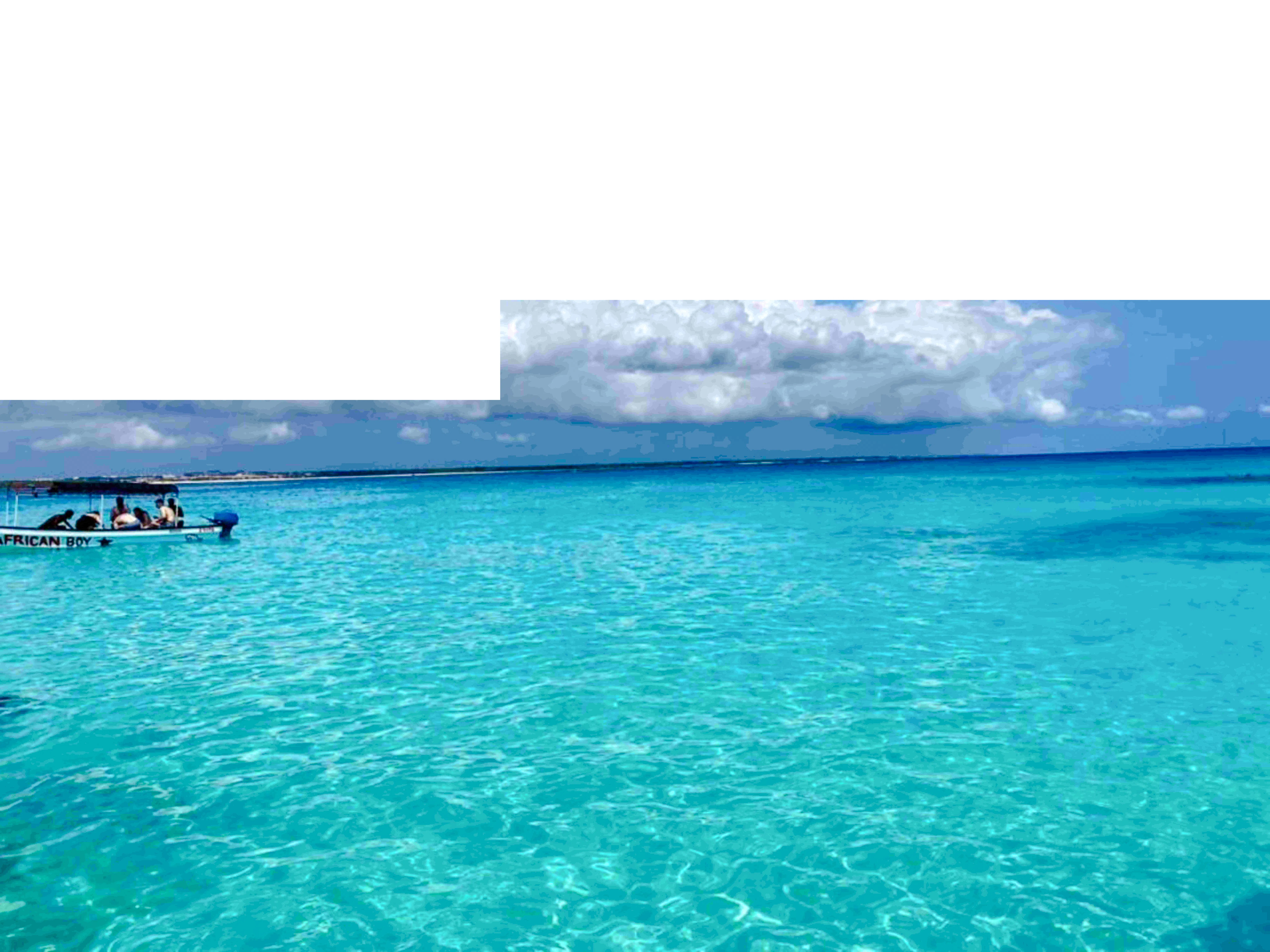 Boat on turquoise waters during Zanzibar Blue Safari snorkeling tour.