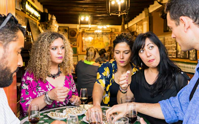 Group enjoying tapas and drinks at a traditional bar in Seville during a tasting tour.